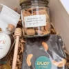 Frasco de vidrio con amarettis artesanales y etiqueta con mensaje junto a tableta de chocolate con frutos secos.