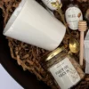 Primer plano de taza de cerámica, frasco de frutos secos y cuchara dorada de diseño en box corazón.