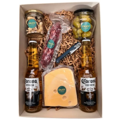 Box cervecero gourmet con cervezas Corona, queso holanda, salamín al vacío y frascos de snacks.