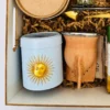 Detalle de lata yerbera celeste con Sol de Mayo dorado y mate artesanal forrado en cuero de Enjoy.