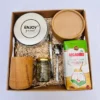 Box matero de regalo con mate de madera de algarrobo, lata yerbera blanca, yerba mate secadero y variada repostería artesanal.