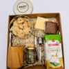 Box matero de regalo con mate de madera de algarrobo, lata yerbera blanca, yerba mate secadero y variada repostería artesanal.