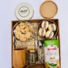 Vista superior de caja kraft con kit matero de madera de algarrobo, alfajores de maicena, galletas