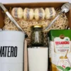Vista superior de box de regalo con yerba mate, cuchara grabada de Enjoy y alfajores artesanales.