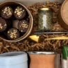 Primer plano de alfajores marplatenses de chocolate, cuchara dorada, bombilla de acero y frasco de burrito.