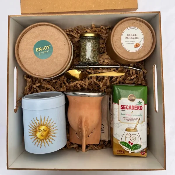Vista cenital de box tradicional argentino con set de mate en cuero, pote de dulce de leche y yerba secadero.
