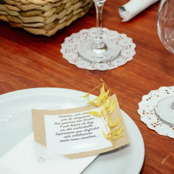 Mesa de comensales armada con plato principal, copa de vidrio y servilleta para banquete.