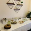 Mesa dulce y candy bar decorado para evento con frascos de vidrio, golosinas y rosquillas.