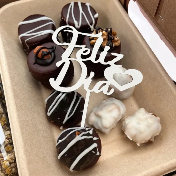 Bandeja ecológica con alfajorcitos bañados en chocolate con frutos secos, glaseados y topper decorativo Feliz Día.