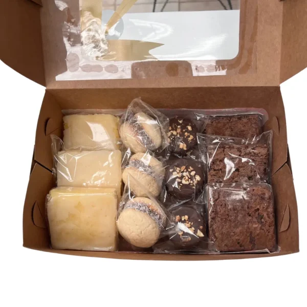 Caja de pastelería abierta con cuadraditos de limón, alfajores de maicena, alfajores de chocolate con crocante y brownies individuales.