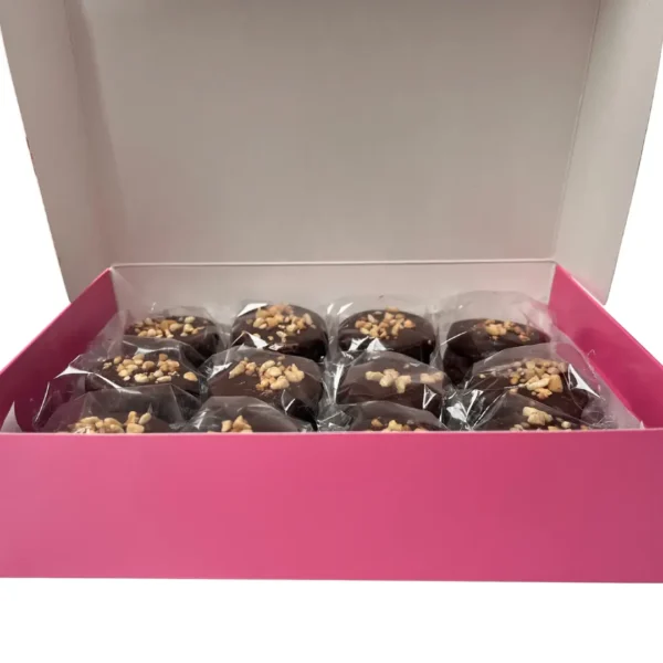 Caja rosa de 12 alfajores de chocolate gourmet envueltos individualmente con crocante de frutos secos de Enjoy y a Picar.